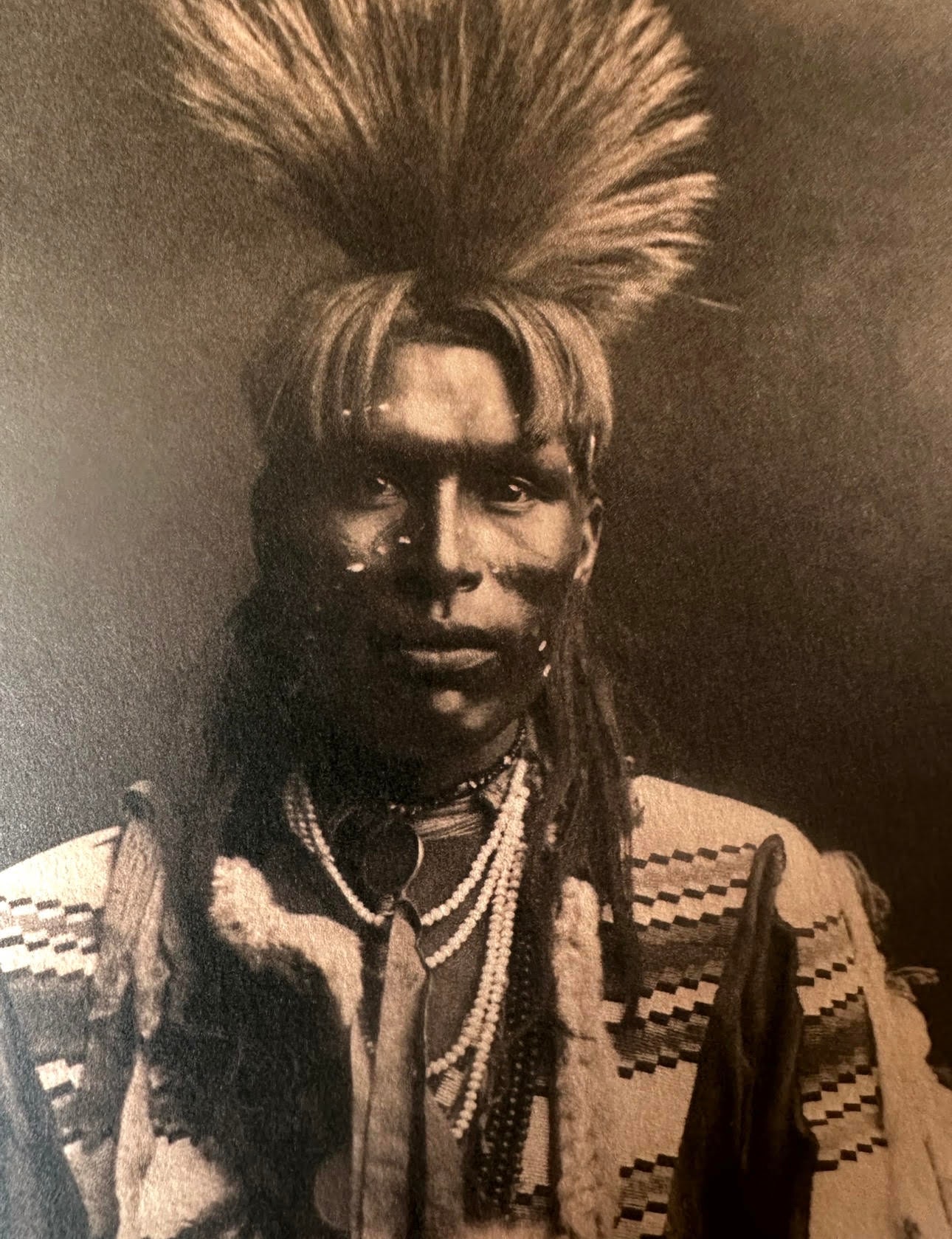 Indigenous North American man in ceremonial headdress and regalia